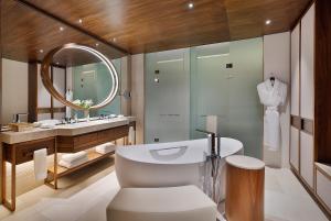 a bathroom with a sink and a toilet and a mirror at Conrad Rabat Arzana in Rabat