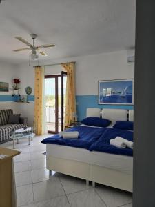 - une chambre avec un lit bleu et un canapé dans l'établissement Apartmani Nata, à Maslinica