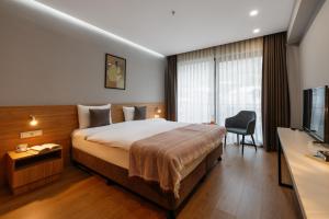 una camera d'albergo con letto e TV di Hotel Memoir Kazbegi by DNT Group a Kazbegi