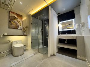 a bathroom with a shower and a toilet and a sink at M&H Hotel in Ho Chi Minh City