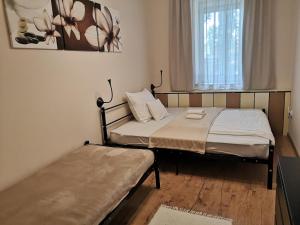 two beds in a small room with a window at Levander Apartmenthouses in Makó