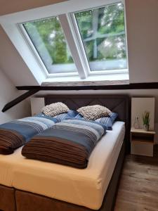 a bed with two pillows on it under a window at Ahrenshof 8 in Bad Zwischenahn