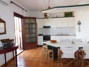 a kitchen with white cabinets and a table and chairs at Thassos Allegro Apartment in Limenaria