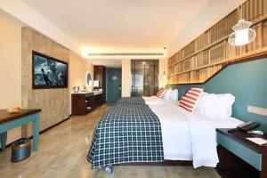 a large bedroom with a large bed and a bathroom at Mehood Theater Hotel, Jinan High -tech Zone Wanda Plaza in Jinan