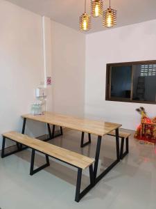 uma mesa e bancos num quarto com uma televisão em JW Homestay Betong เจ ดับบลิว โฮมสเตย์ เบตง em Betong