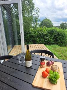 uma mesa com uma garrafa de vinho e alguns vegetais em Glyngøre Camping og Hytte by em Glyngøre