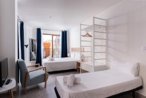 阿利坎特的住宿－Apartamentos Quijano by Be Alicante，一间卧室配有两张床、一张桌子和一把椅子