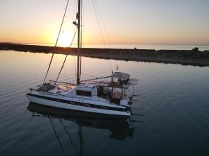 una barca a vela seduta in acqua al tramonto di Barco Casa Fuzeta a Fuzeta