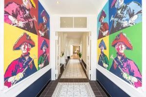 a hallway with colorful paintings on the walls at Schlosshotel Rheinsberg in Rheinsberg