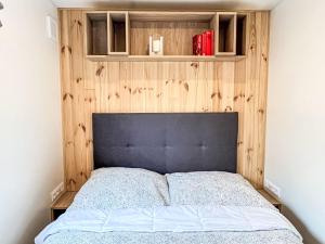 ein Schlafzimmer mit einem Bett mit einer Holzwand in der Unterkunft Holiday Home Petra by Interhome in Wemding