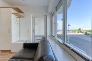 a living room with a couch and a large window at Alte Teestube 69 2 Raum in Norderney