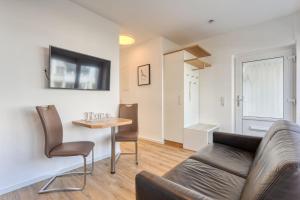 ein Wohnzimmer mit einem Sofa und einem Tisch in der Unterkunft Alte Teestube 69 2 Raum in Norderney