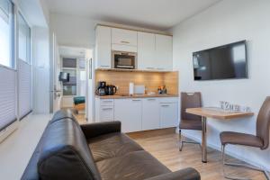 ein Wohnzimmer mit einem Sofa und einer Küche in der Unterkunft Alte Teestube 69 2 Raum in Norderney