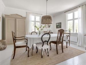 ein Esszimmer mit einem weißen Tisch und Stühlen in der Unterkunft Holiday Home Idyllen - VML115 by Interhome in Skinnskatteberg