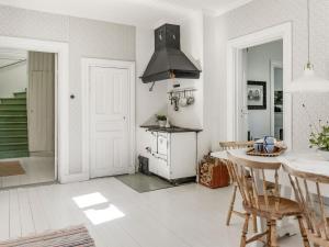eine Küche mit einem Herd und einem Tisch mit Stühlen in der Unterkunft Holiday Home Idyllen - VML115 by Interhome in Skinnskatteberg