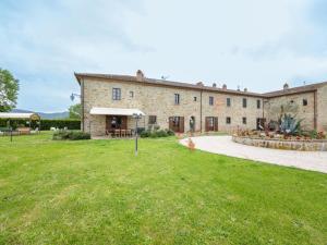 um grande edifício de pedra com um campo de relva em frente em Apartment Il Grifone-3 by Interhome em Cortona