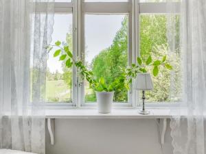 ein Fenster mit einer Pflanze auf einem weißen Fensterbrett in der Unterkunft Holiday Home Idyllen - VML115 by Interhome in Skinnskatteberg
