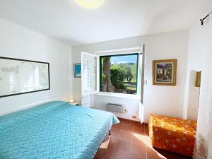 ein Schlafzimmer mit einem blauen Bett und einem Fenster in der Unterkunft Sant'Anna del Volterraio - Strada Maestra (56) in Bagnaia