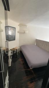 ein Schlafzimmer mit einem weißen Bett und einem Tisch in der Unterkunft Duplex spagiari in Nizza