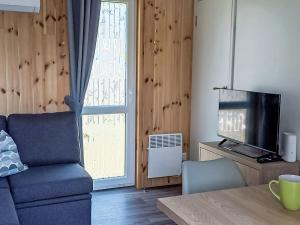 a living room with a couch and a television at Holiday Home Lieblingsplatz by Interhome in Wemding