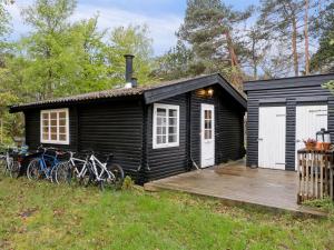 a black house with bikes parked outside of it at Holiday Home Giertrud - 1-1km from the sea in Sealand by Interhome in Vig