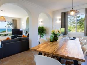 a dining room and living room with a wooden table and chairs at Villa Atardecer by Interhome in Torrox Costa