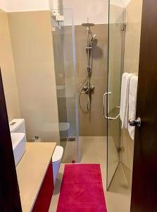 La salle de bains est pourvue d'une douche et d'un tapis rouge. dans l'établissement Negombo Ocean Breeze Luxury Studio by Serendib Vacation, à Negombo