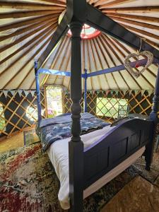 Bett in einer Jurte mit Holzdecke in der Unterkunft Granville House Glamping in Ballyferriter