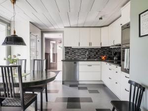 SandhemにあるHoliday Home Flugebacken by Interhomeの白いキャビネットとテーブルと椅子のあるキッチン