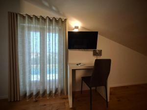 a desk with a chair and a television on a wall at Villa dei tigli - Altamura in Altamura