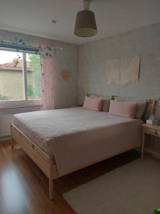 a bedroom with a large bed with pink pillows at feel like your own home in Linköping