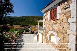 a stone building with a pathway leading to a house at Appartamenti Tanaunella in Budoni