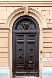 a black door on a building with an arch at IL Sole in Rome