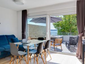 ein Wohnzimmer mit einem blauen Sofa, einem Tisch und Stühlen in der Unterkunft Apartment Gavun by Interhome in Bibinje