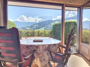 a table and two chairs in front of a window at Charmant studio près du centre de Combloux avec kitchenette - FR-1-560-54 in Combloux +2 photos