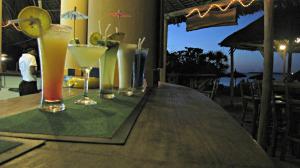 Kipepeo Beach and Village في دار السلام: صف من المشروبات على طاولة خشبية