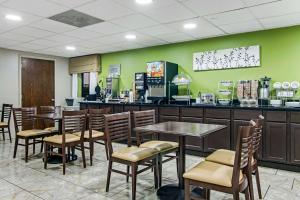 a restaurant with tables and chairs and green walls at Sleep Inn near I-80 and I-94 in Lansing