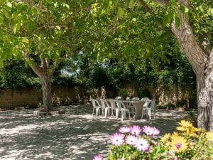 stół i krzesła pod drzewami i kwiatami w obiekcie Villa Le Cascate by Interhome w mieście Saturnia