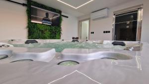 un bagno con tre lavandini e una TV a parete di Modern Luxurious Villa with SPA-Adria Resort a Tisno (Stretto) Altre 127 foto