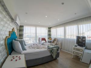 een slaapkamer met een groot bed en een televisie bij Grand Esen Hotel in Istanbul