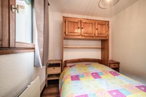 una piccola camera con letto e armadi in legno di Les Avenières a Châtel