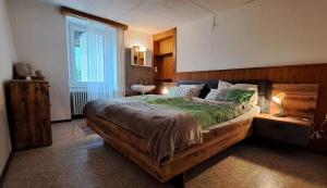 a bedroom with a large wooden bed in a room at Ristorante della Posta Carena in Carena