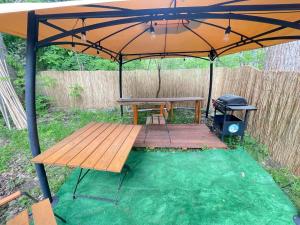 een picknicktafel en een grill onder een paraplu bij Your Camp Hel in Hel