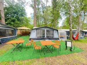 een camping met tafels, stoelen en tenten bij Your Camp Hel in Hel
