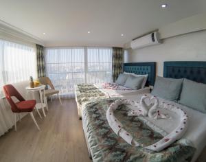 een hotelkamer met 2 bedden en een hartvormig bed bij Grand Esen Hotel in Istanbul