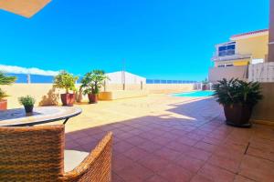 a patio with a table and chairs and the beach at Comfortable 2 bed in Arguineguín in Arguineguín
