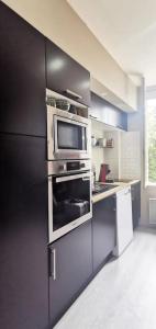 a kitchen with an oven and a microwave at Maison Village Cosy - Wifi - 2 VTT - 5 km plage in Villelongue-de-la-Salanque