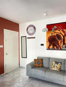 ein Wohnzimmer mit einer Couch und einer Uhr an der Wand in der Unterkunft Pafia A in Paphos City