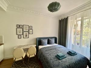 ニースにあるStudio 2 steps from the sea near the Negresco hotelのベッドルーム1室(ベッド1台、椅子2脚、窓付)