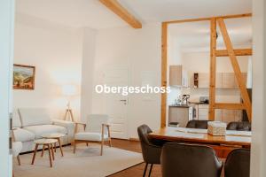 een keuken en woonkamer met een tafel en stoelen bij Alte Münze Apartments in Goslar